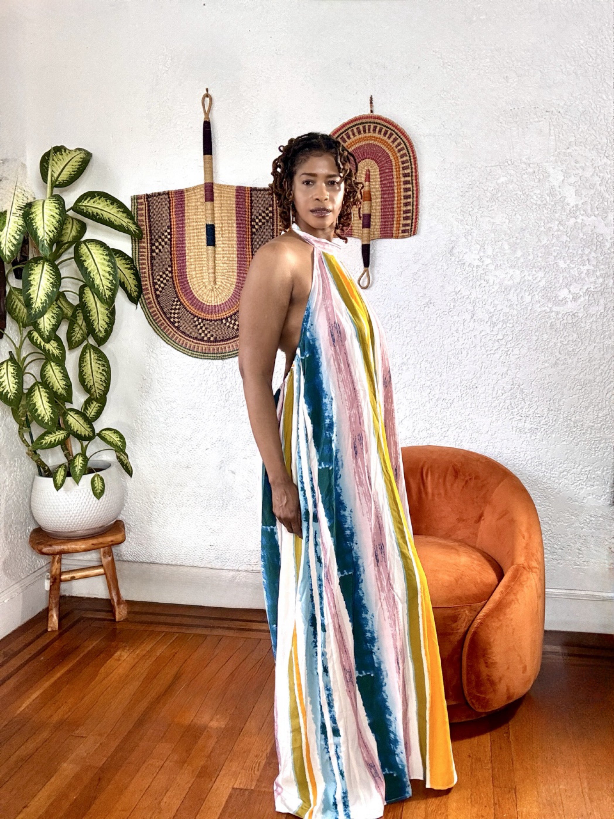 Side angle of the Sunset Drip Halter Jumpsuit showing the halter tie neck and wide-leg silhouette.