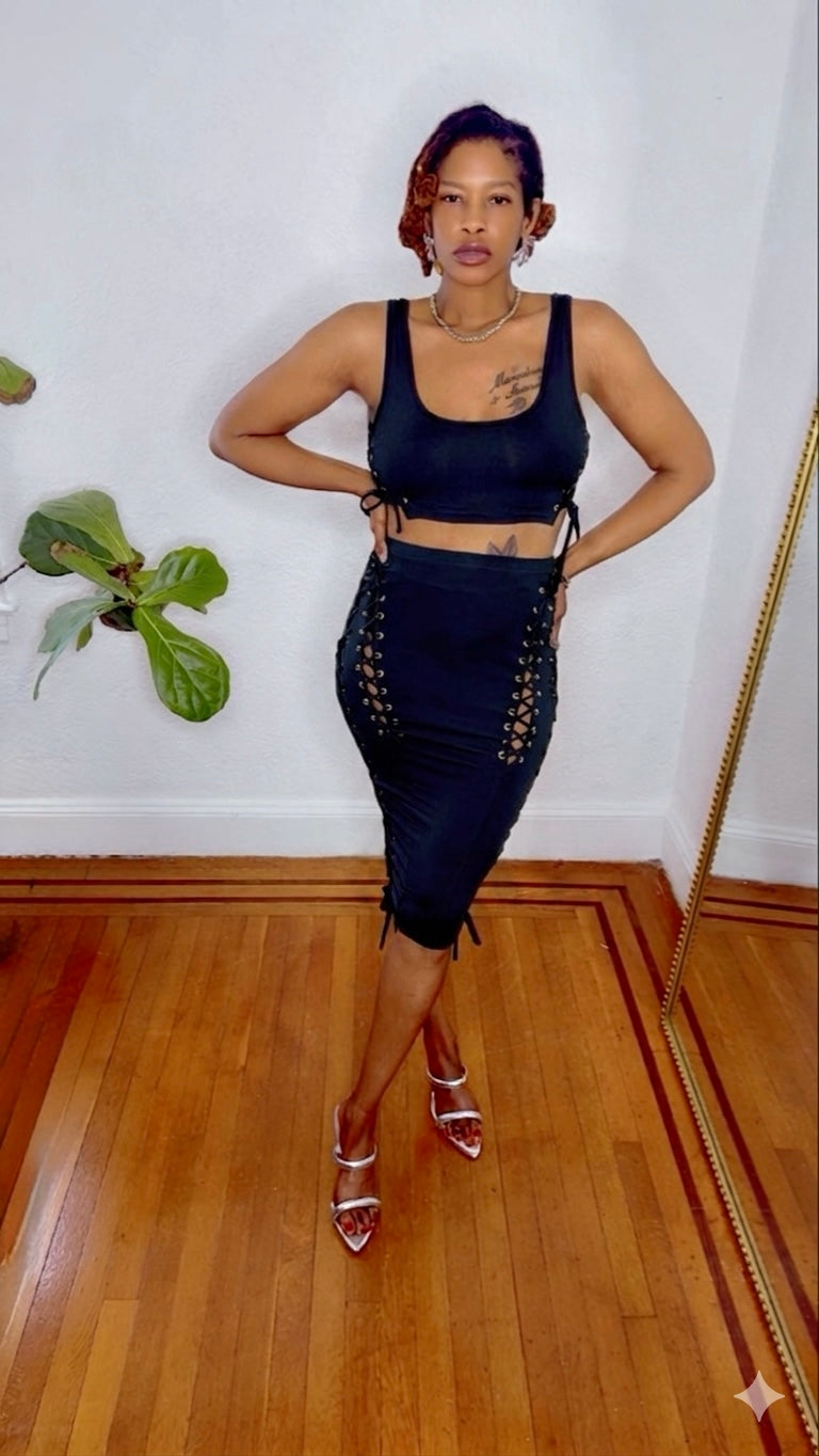 Black Swan Lace Dress in black — front view showing lace-up side detailing and body-hugging midi length from MonologueClosets