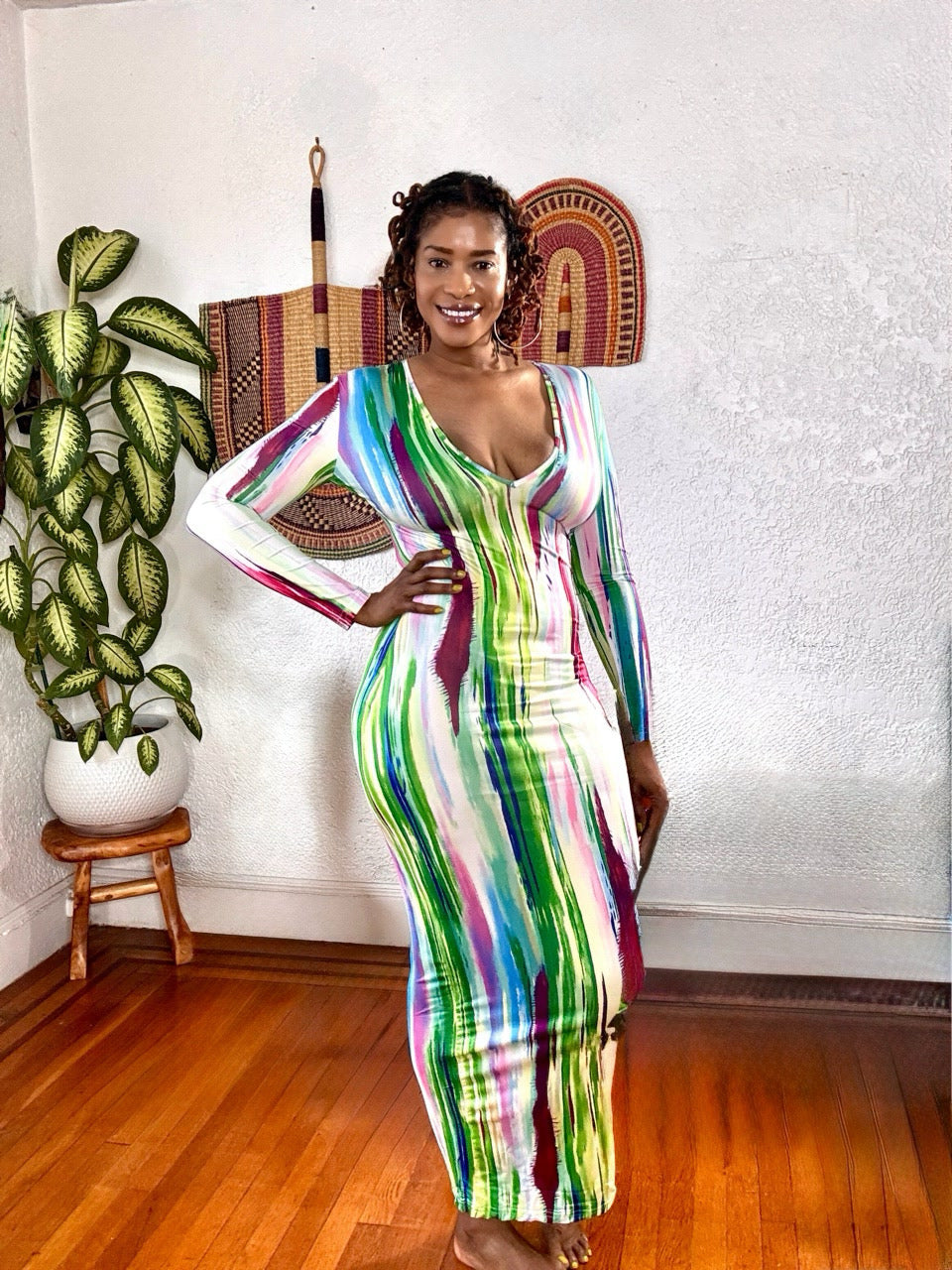 Model wearing the Brushstroke Baddie Bodycon Maxi Dress featuring a multicolor abstract print and deep V-neckline.