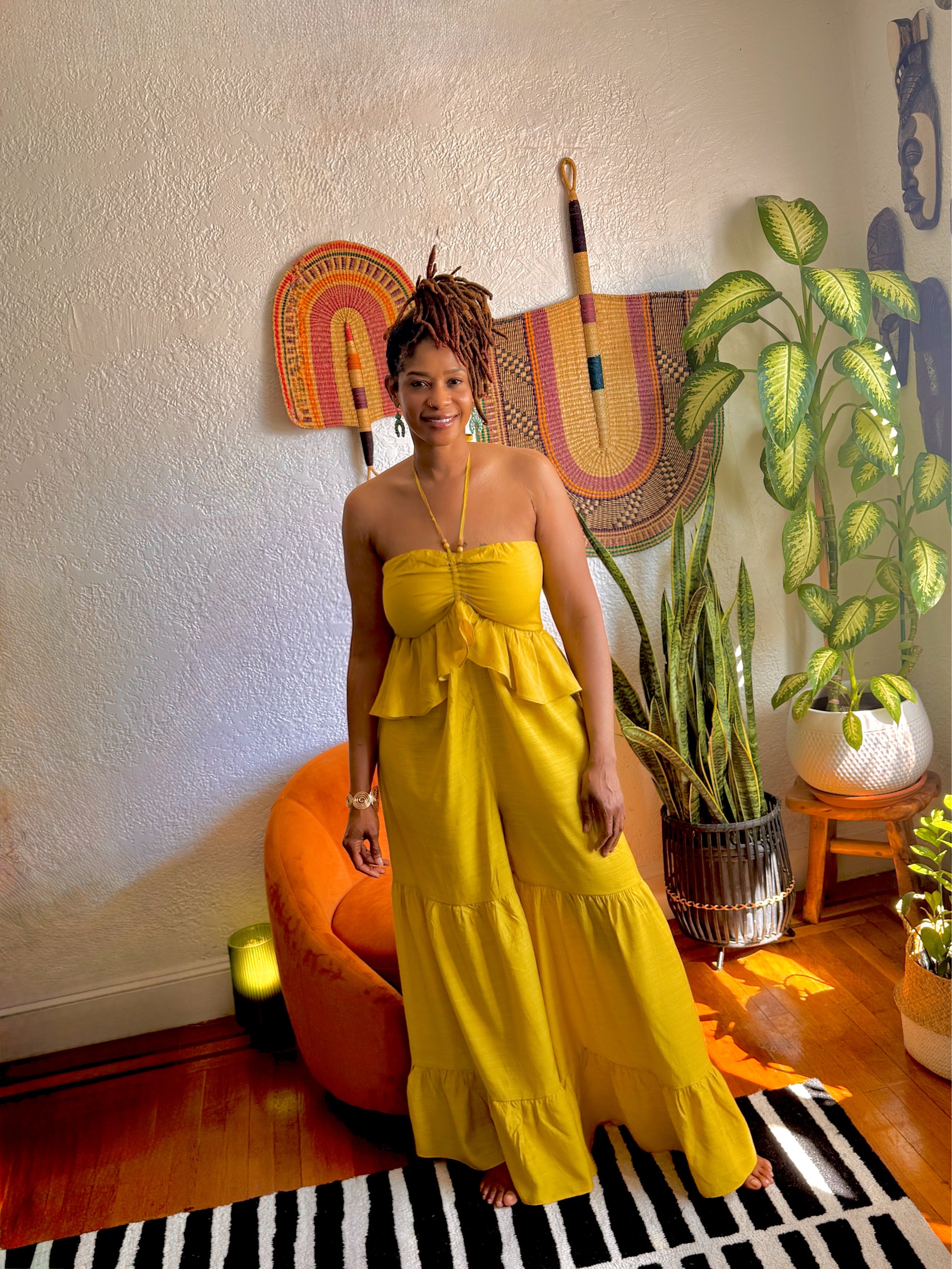 “Model seated in the Butterfly Ruffle Romper, showcasing lightweight mustard fabric and relaxed fit.”