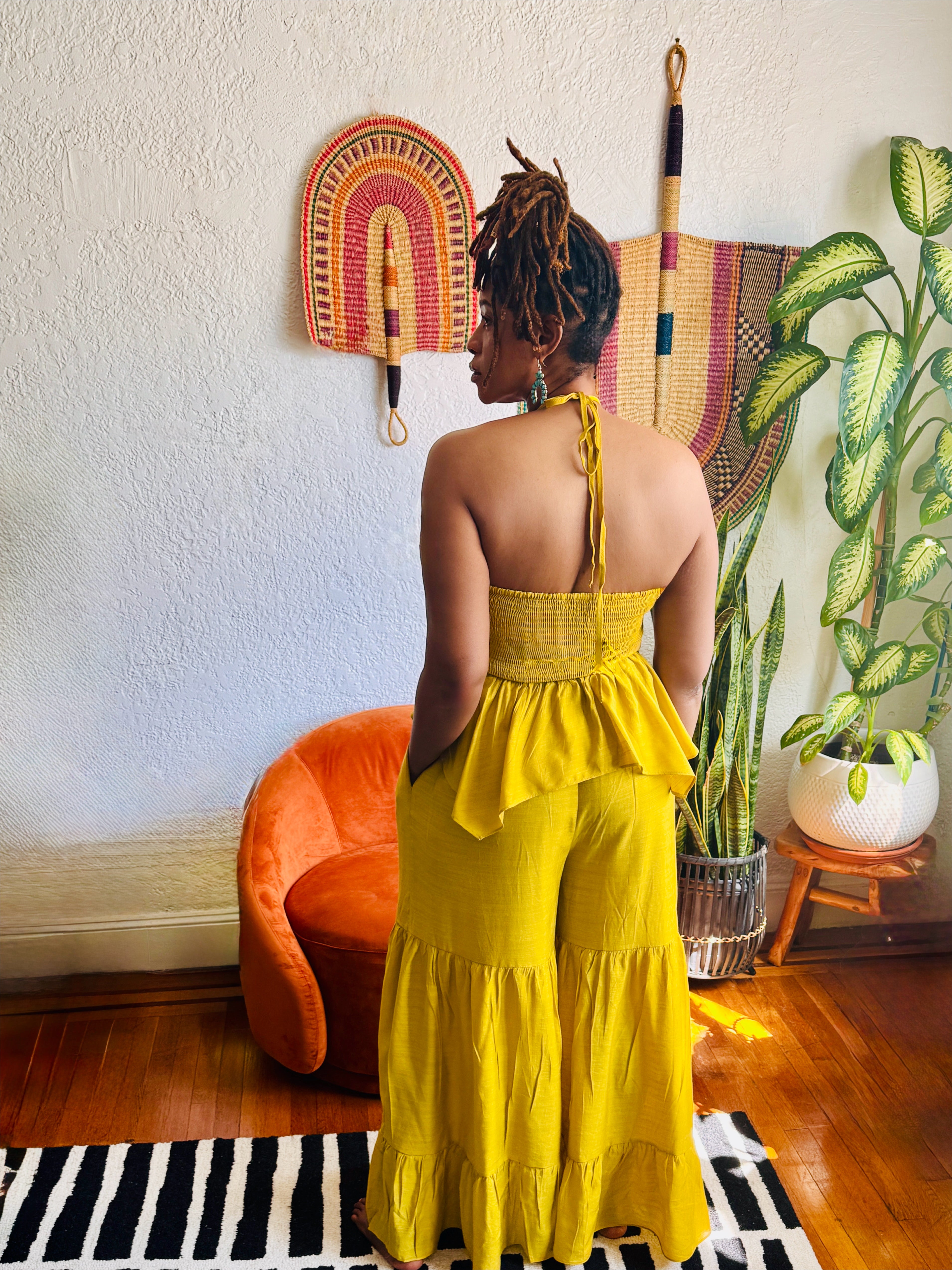 Back view of Butterfly Ruffle Romper showing smocked back and open halter tie detail.