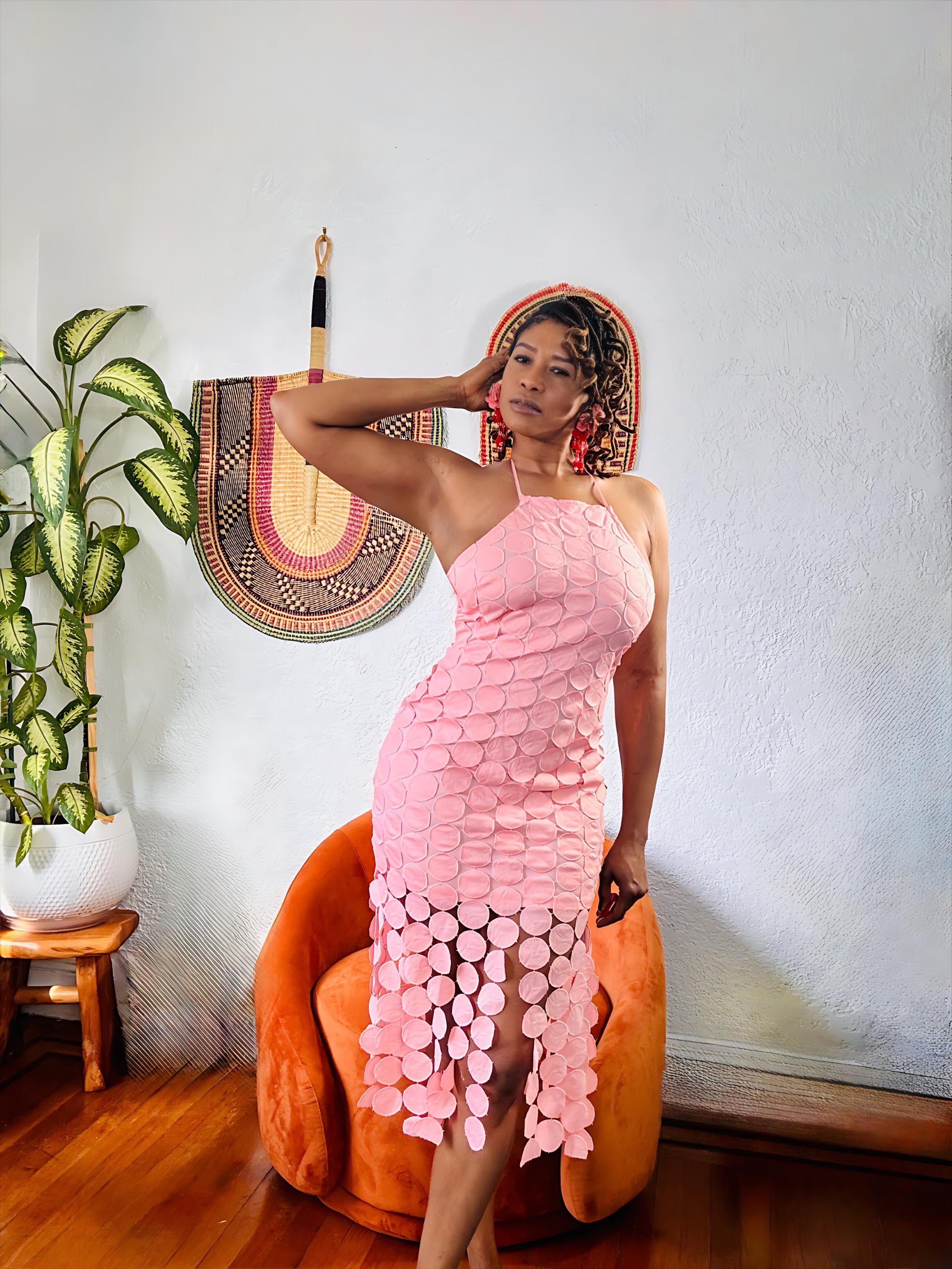 “Model seated in the Circled Then Ends Dress, showing soft blush tone and elegant tiered texture.”