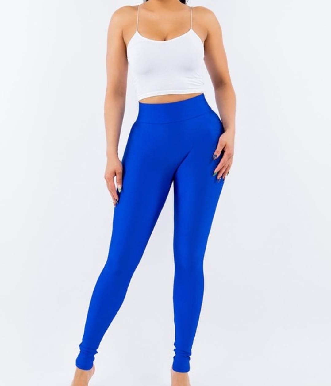 Woman wearing high-waisted cobalt blue leggings with a smooth, sculpting fit.