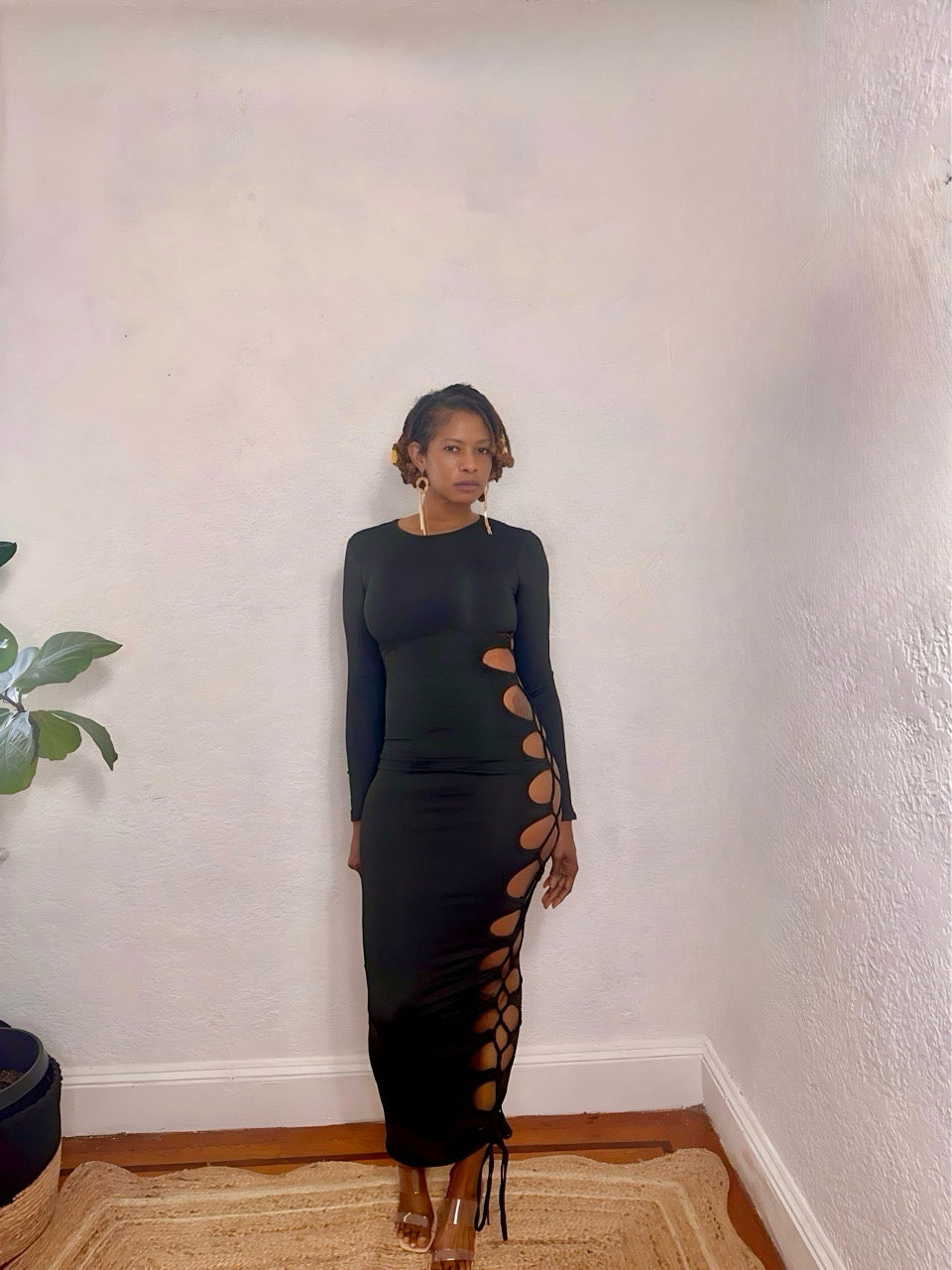 Model wearing the Danger Curve Cutout Maxi Dress in black — side view showing bold cutout design.
