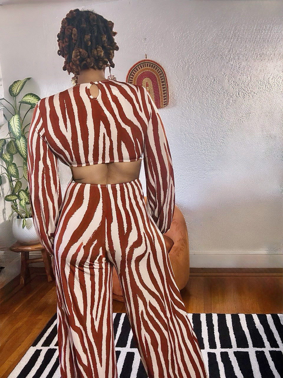 Back of the MAKE ME WILD Zebra Print Jumpsuit highlighting open-back detail and bold zebra stripe pattern.
