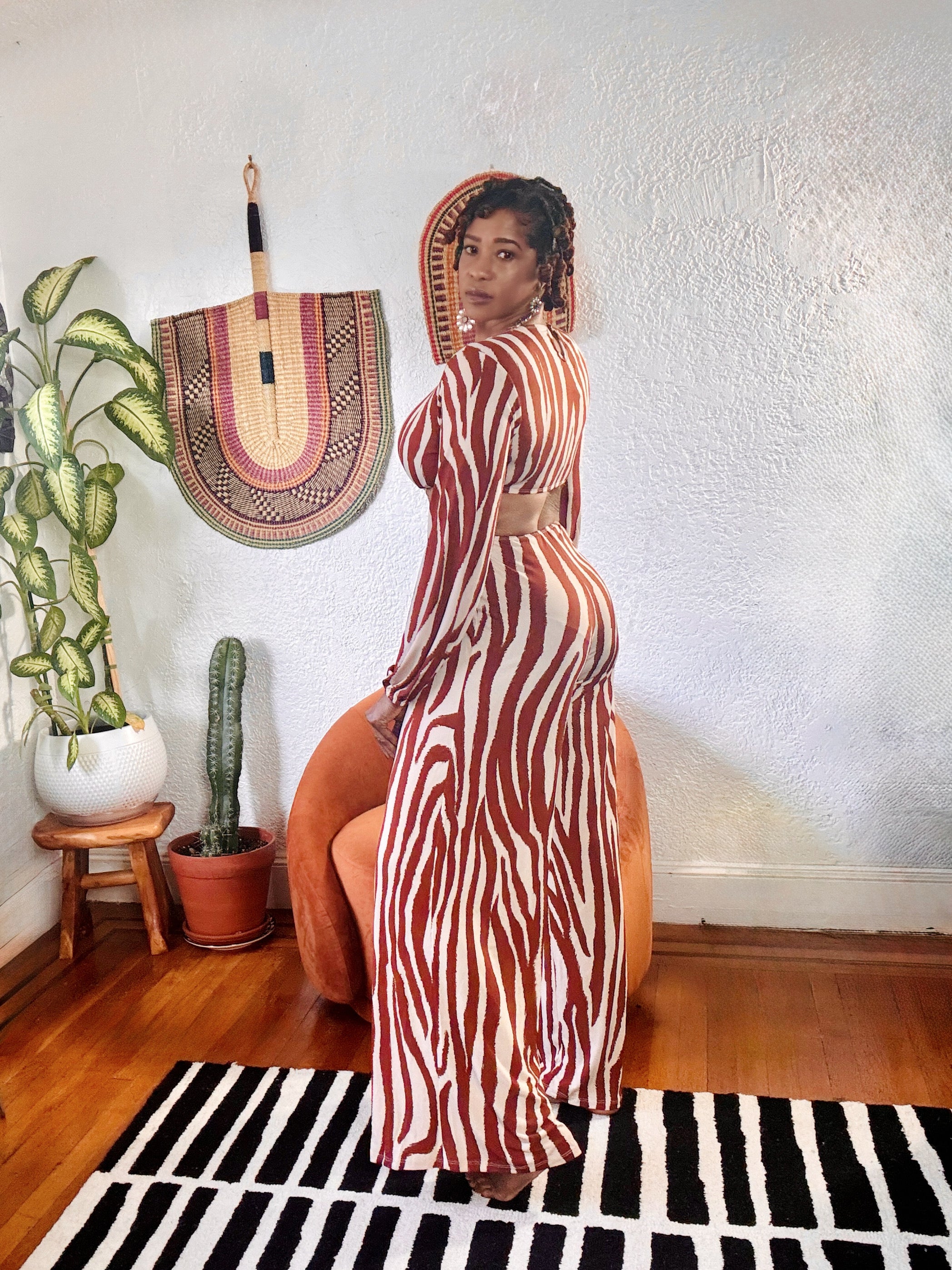 Side angle of the MAKE ME WILD Zebra Print Jumpsuit showing wide-leg fit, waist cut-out, and flattering bodycon silhouette.