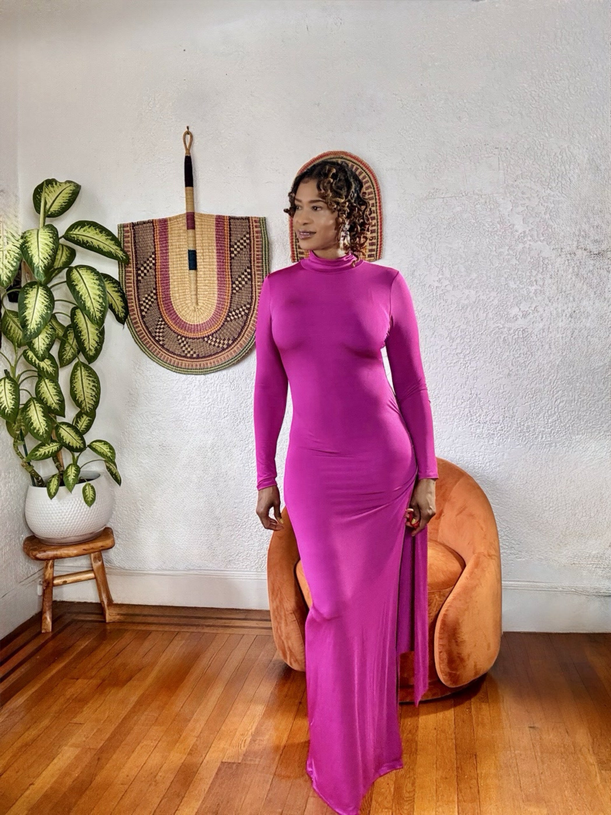 Model posing in the Magenta Muse Maxi Dress near neutral décor, showcasing rich color and luxe fabric texture.