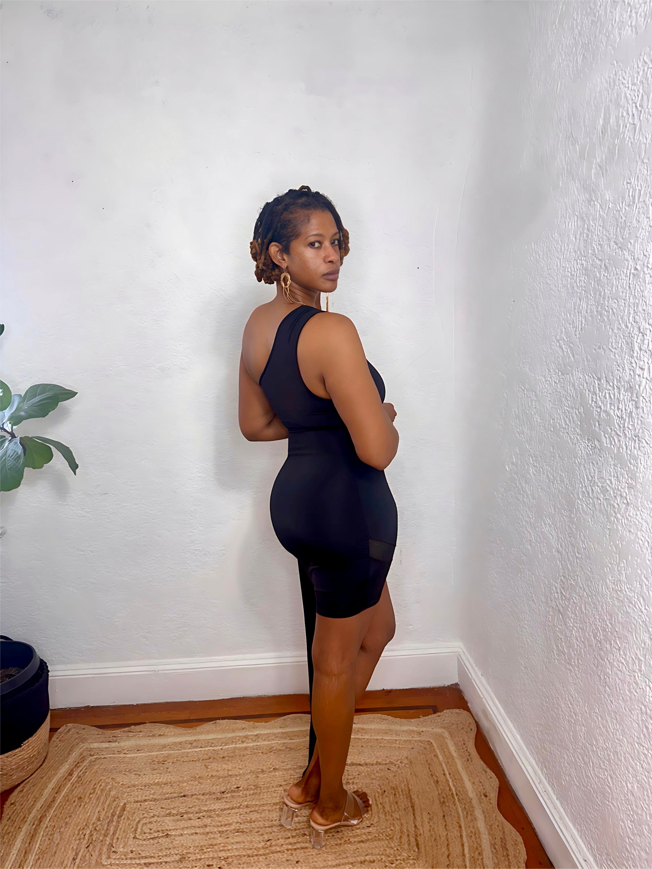 Model posing in the Nightfall One-Shoulder Dress under soft lighting showing the sleek black tone.