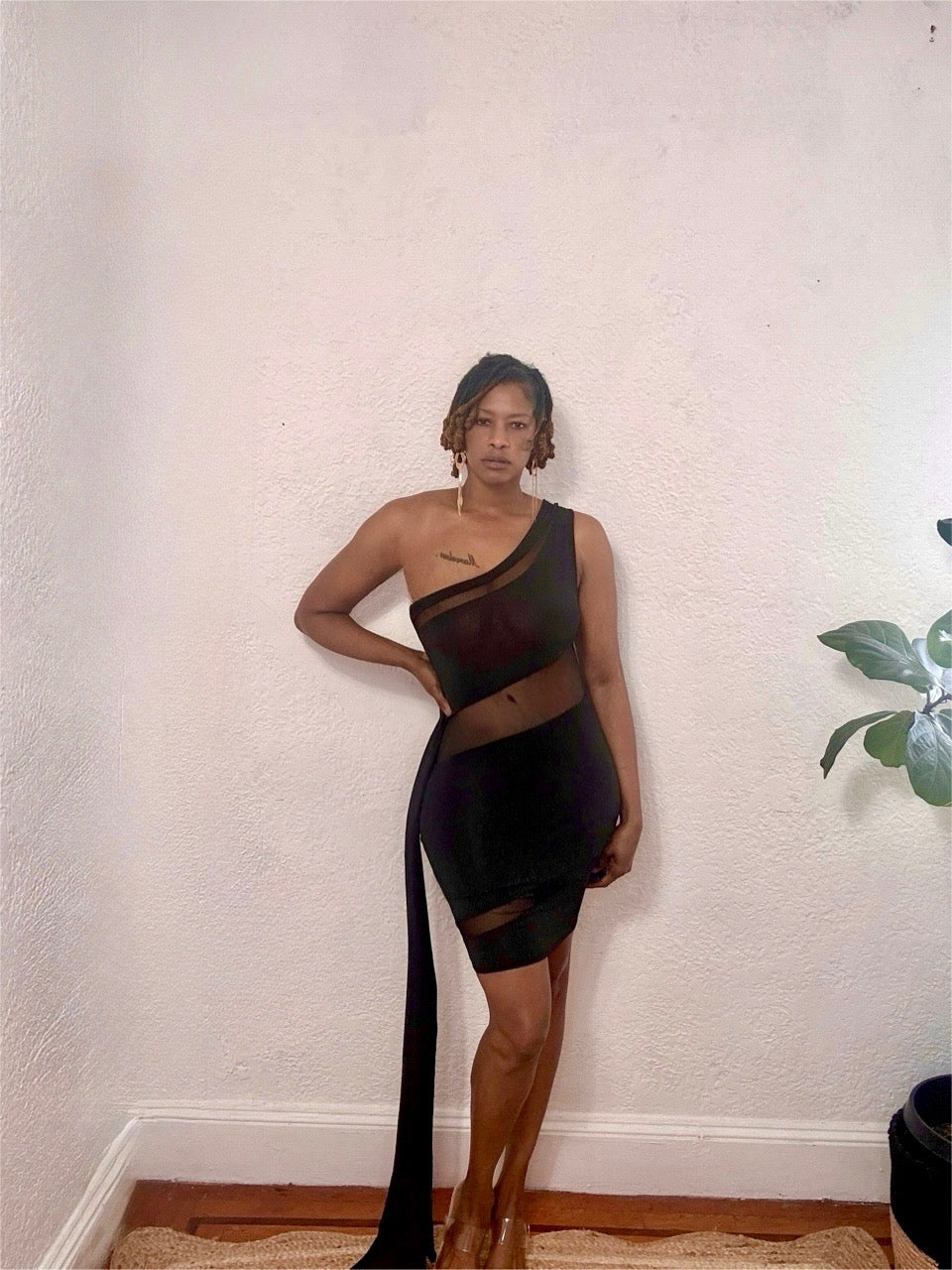 Model wearing the Nightfall One-Shoulder Dress in black with sheer mesh panels and body-hugging fit.
