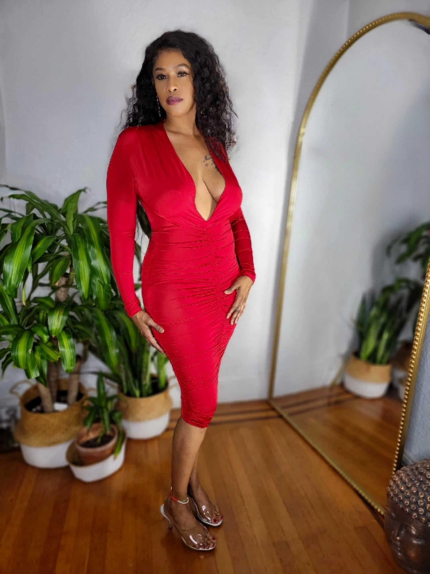 Side view of model wearing the Red Hot Affair Dress showing ruched detailing and curve-hugging fit.