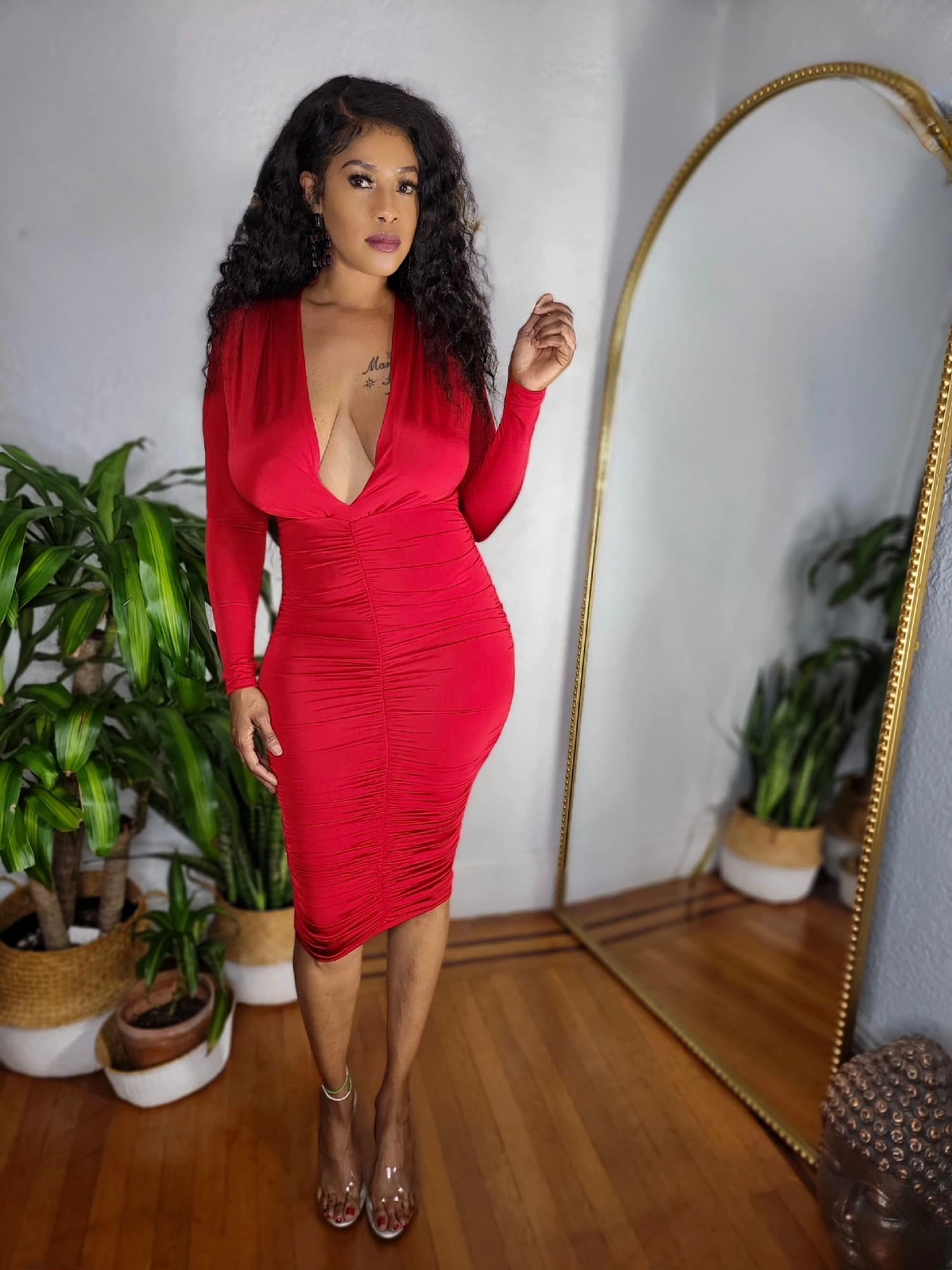 Side view of model wearing the Red Hot Affair Dress showing ruched detailing and curve-hugging fit.