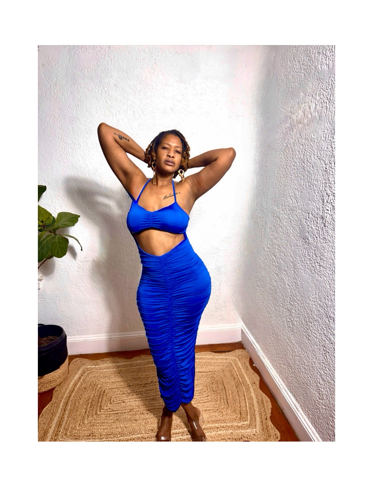 Model posing in royal blue ruched dress styled with silver heels.