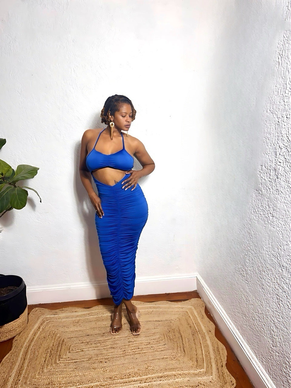 Model wearing royal blue ruched cut-out midi dress with twist bust detail.