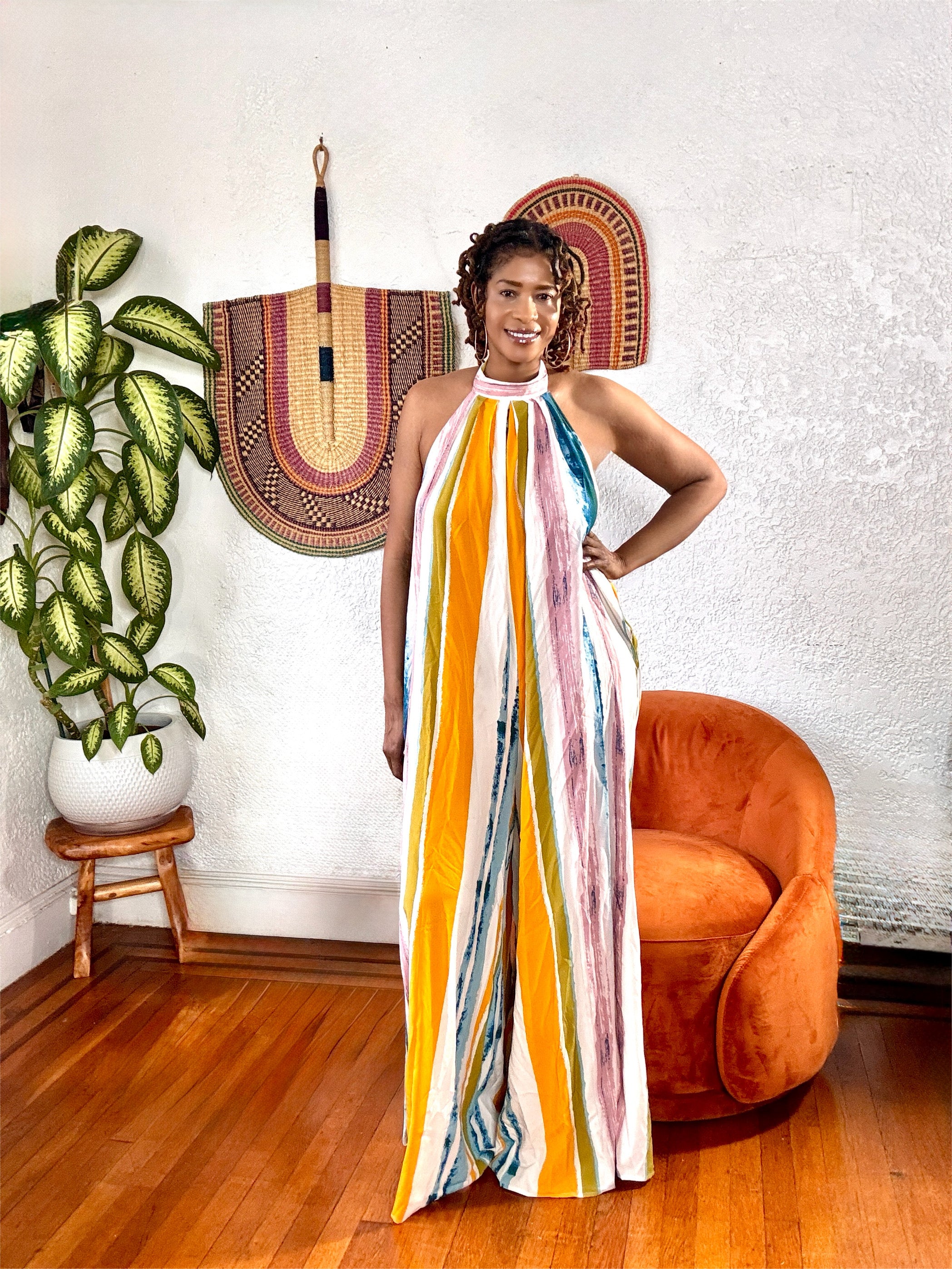 Full-body view of the Sunset Drip Halter Jumpsuit highlighting its vertical stripes and relaxed, lightweight fit.
