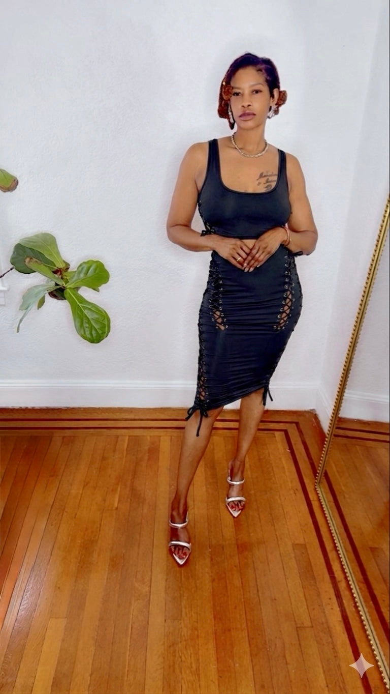 Black Swan Lace Dress in black —black-swan-lace-dress-full-length showing lace-up side detailing and body-hugging midi length from Monologue Closets