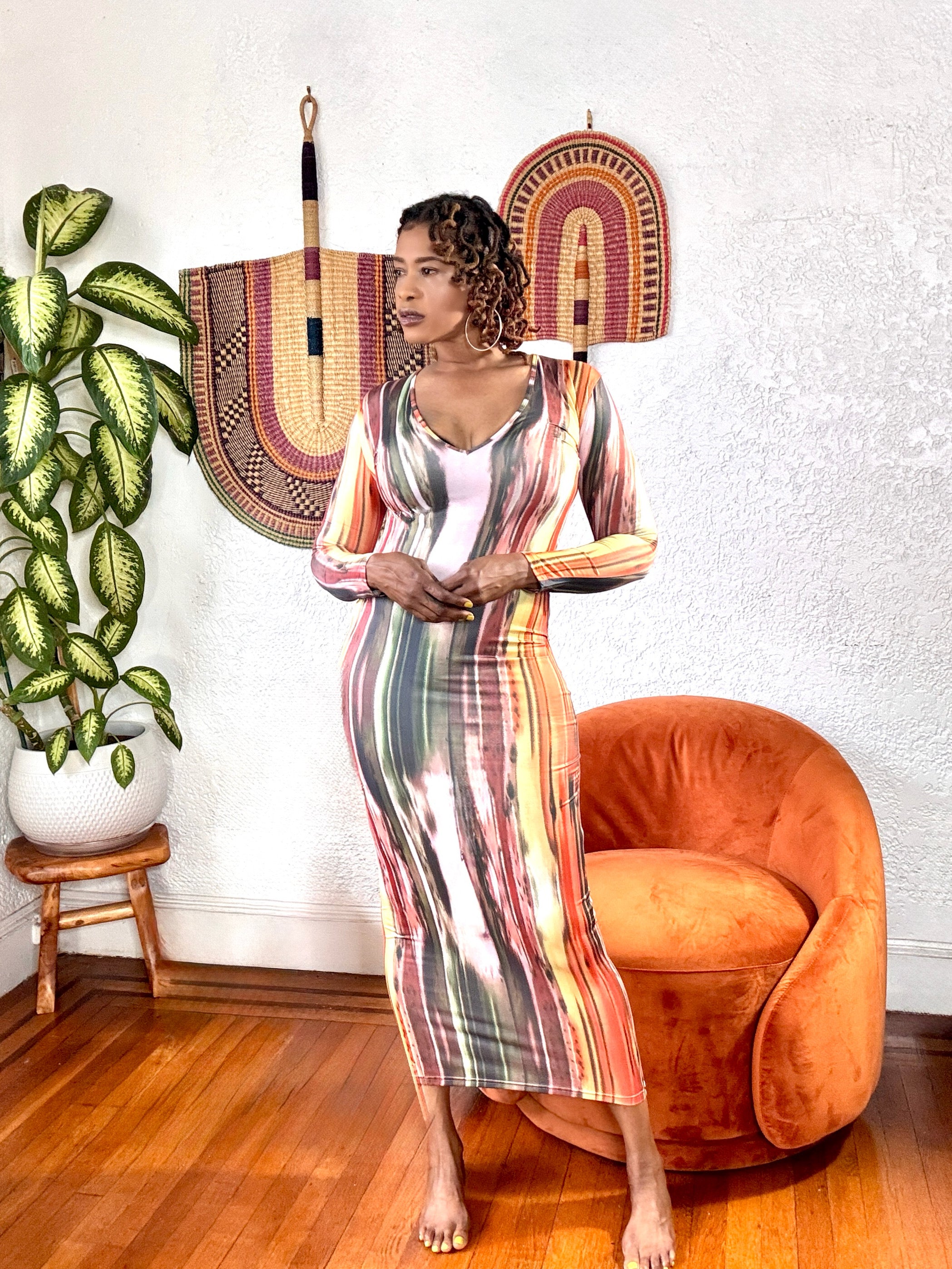 Model wearing the Brushstroke Baddie Bodycon Maxi Dress featuring a multicolor abstract print and deep V-neckline.